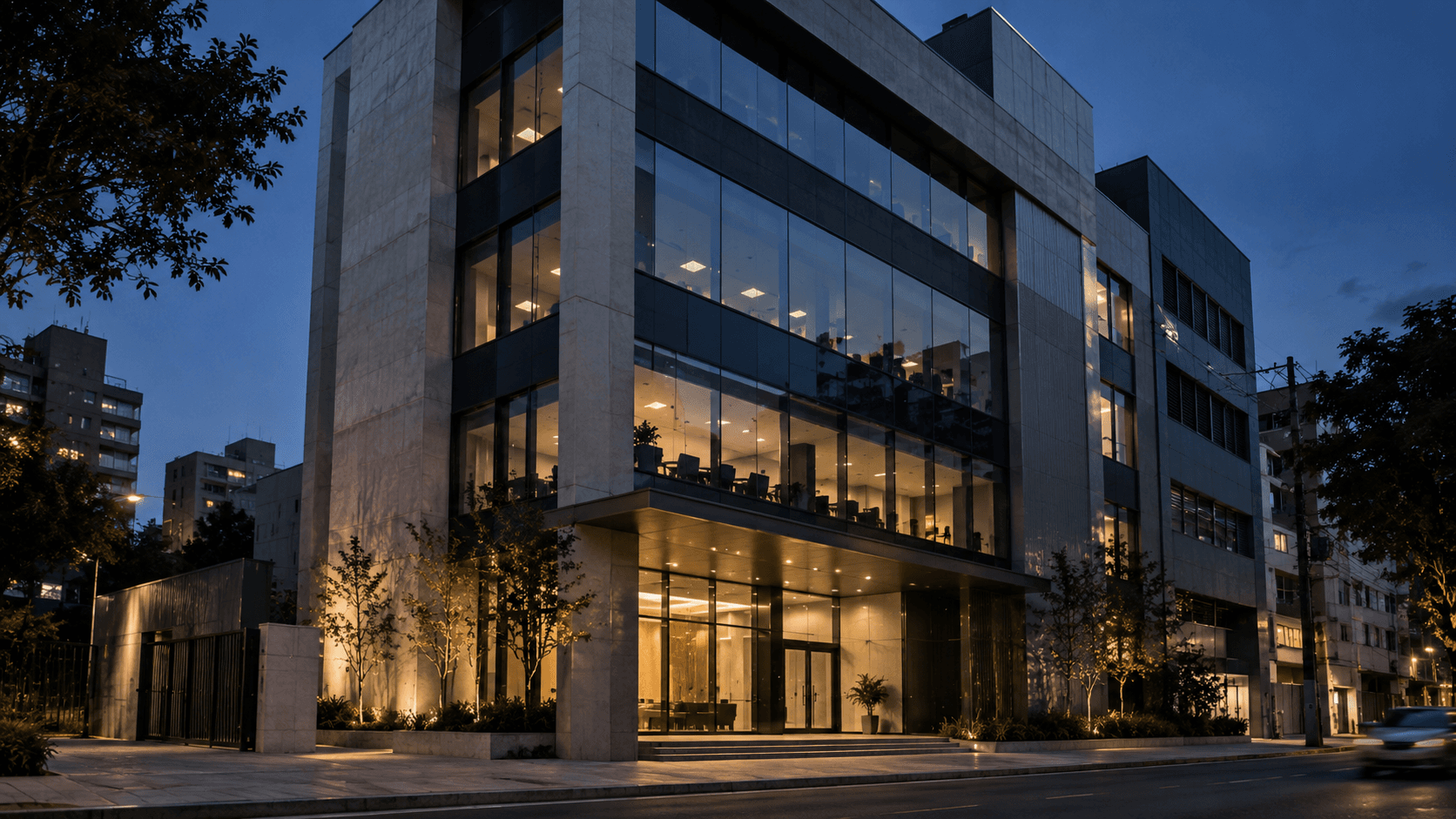 Edifício empresarial contemporâneo concluído, com fachada de vidro iluminada à noite